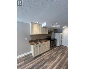 A kitchen with wooden floors and cabinets.