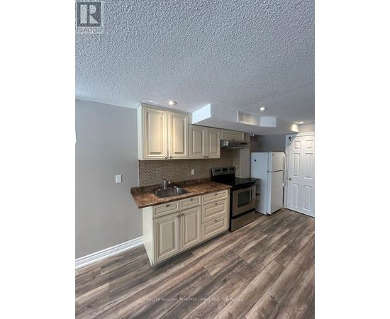 A kitchen with wooden floors and cabinets.