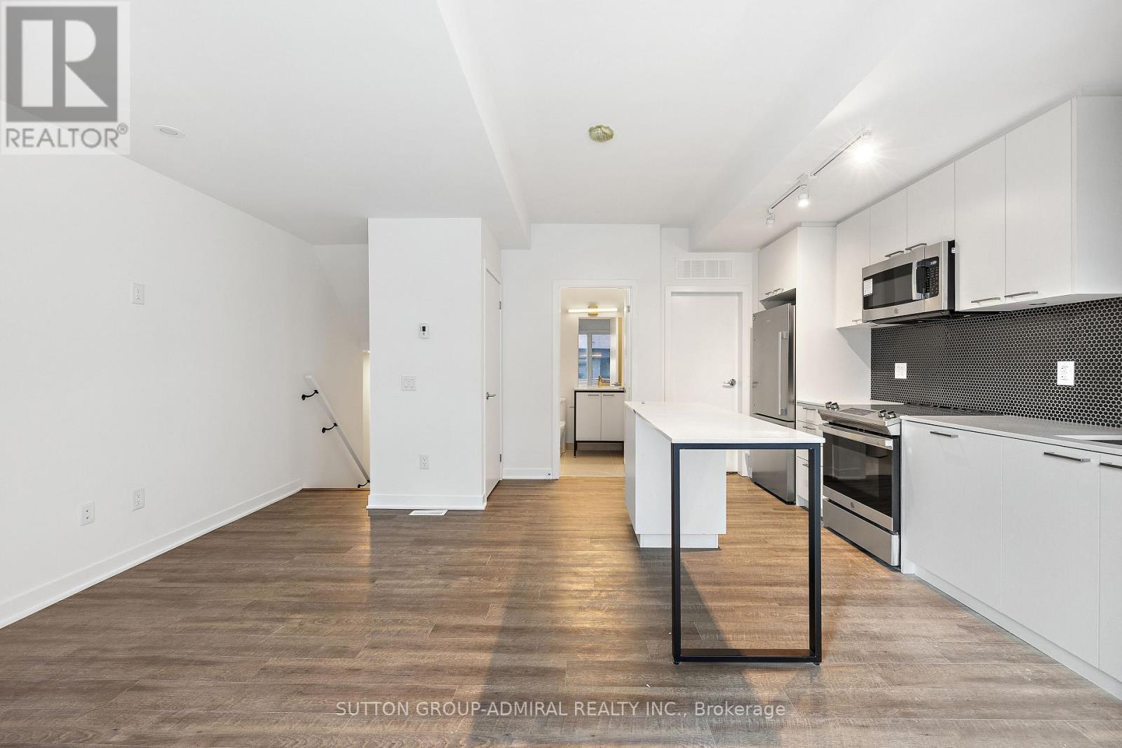 A kitchen with white cabinets and a black countertop.