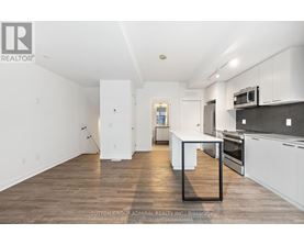 A kitchen with white cabinets and a black countertop.