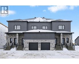 A large house with a grey roof and a stone facade is surrounded by snow.