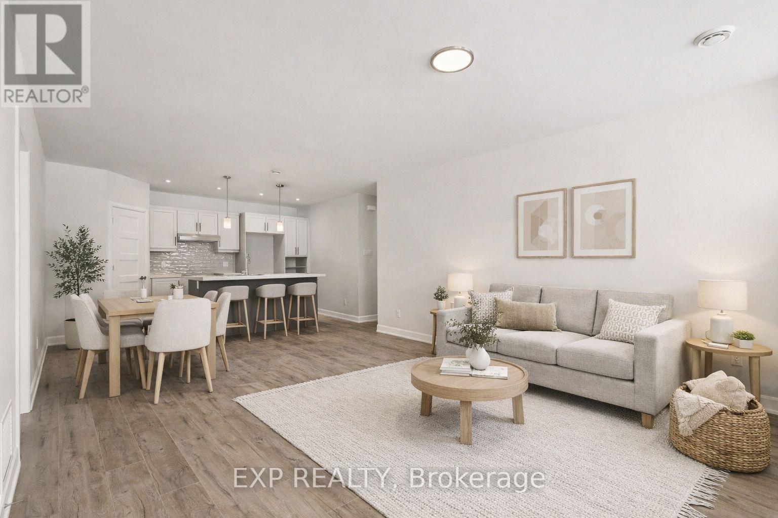 A well-lit, spacious living room with a dining area and a kitchen in the background.