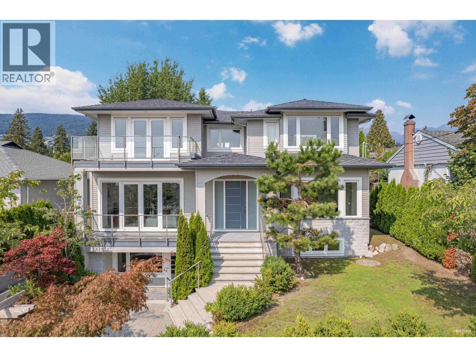 A large, two-story house with a balcony and a deck.