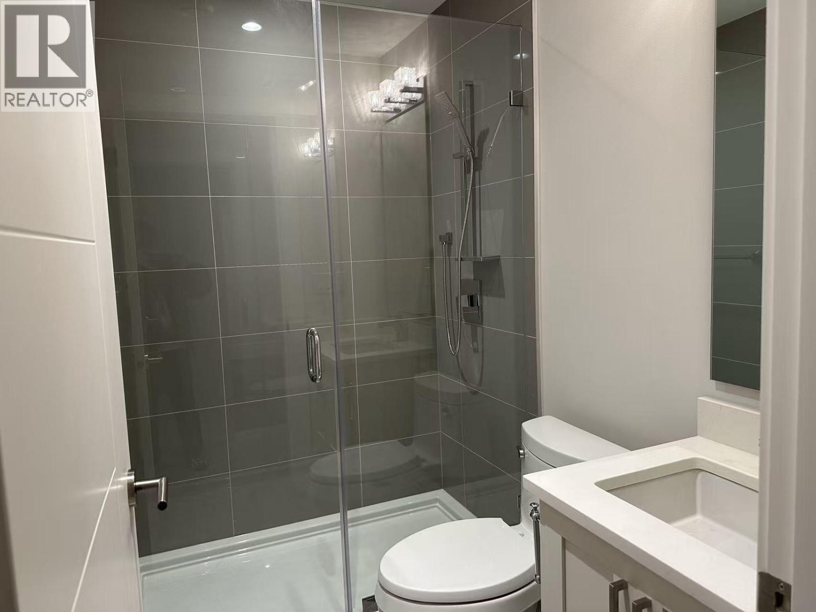 A white toilet in a glass shower stall.