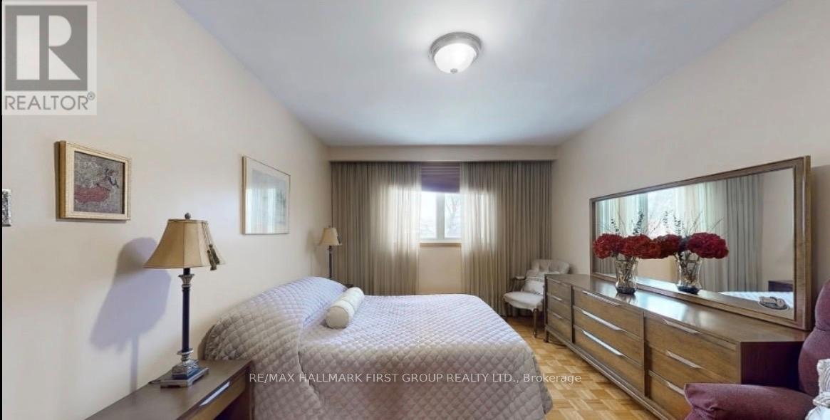 A bedroom with a bed, dresser, and mirror.