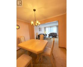 A dining room with a table and chairs.