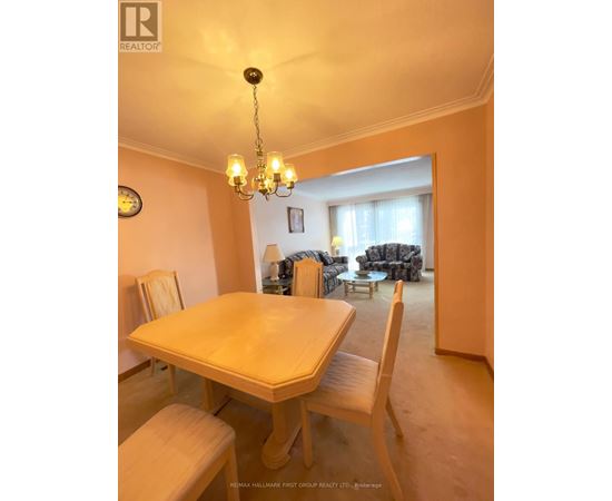 A dining room with a table and chairs.