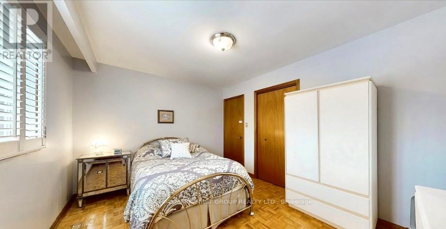 A bedroom with a bed, nightstand, and a window with blinds.