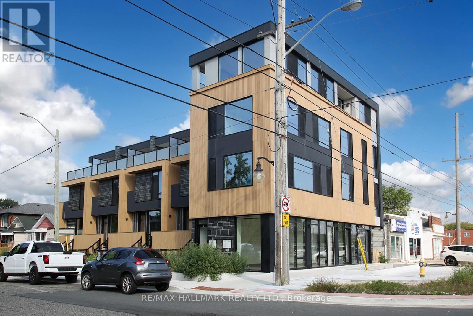 A modern building with a glass facade and a sign that reads "RE/MAX Hallmark Realty.".