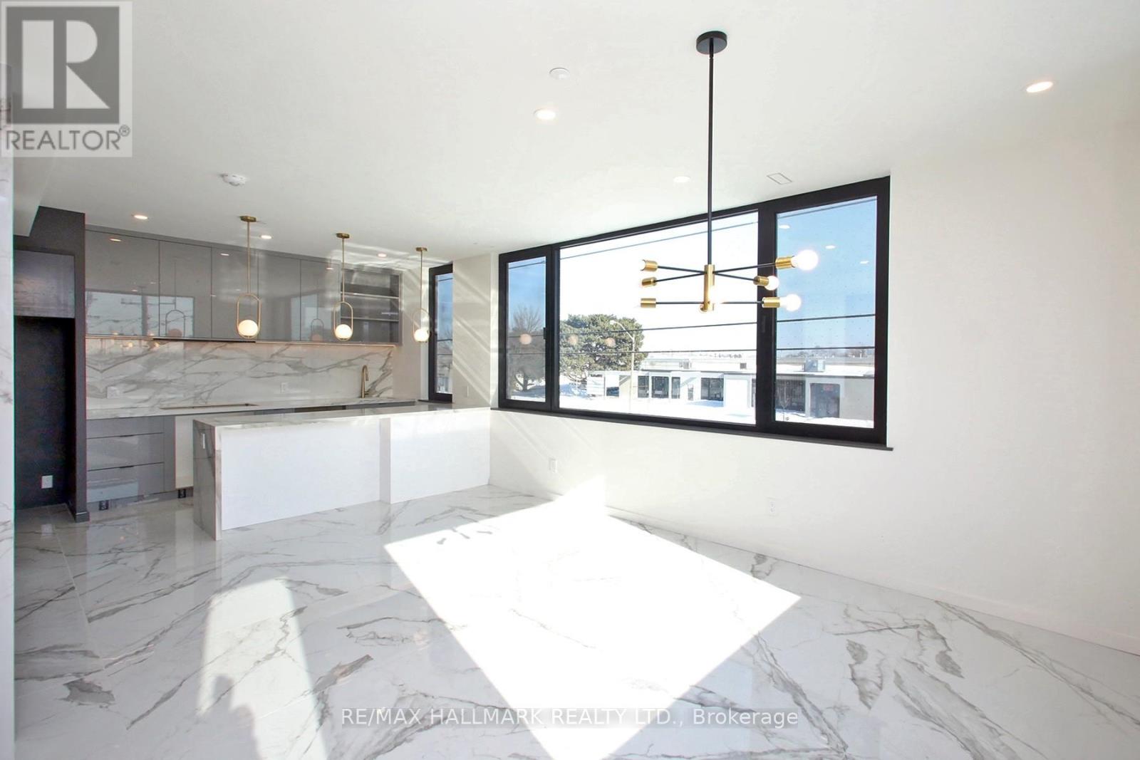 A spacious, modern room with a marble floor and a view of the outside through large windows.