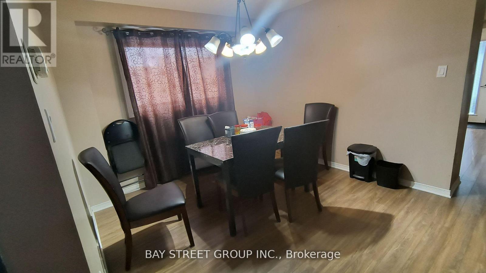 A dining room with a table and chairs.