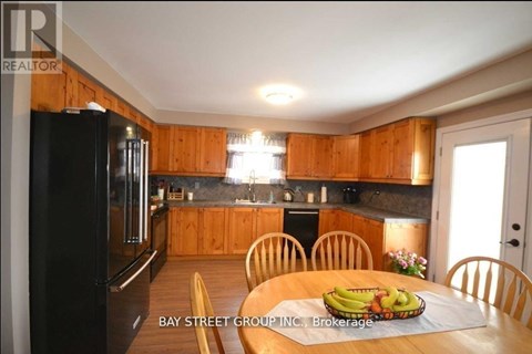 A kitchen with wooden cabinets and a black refrigerator.