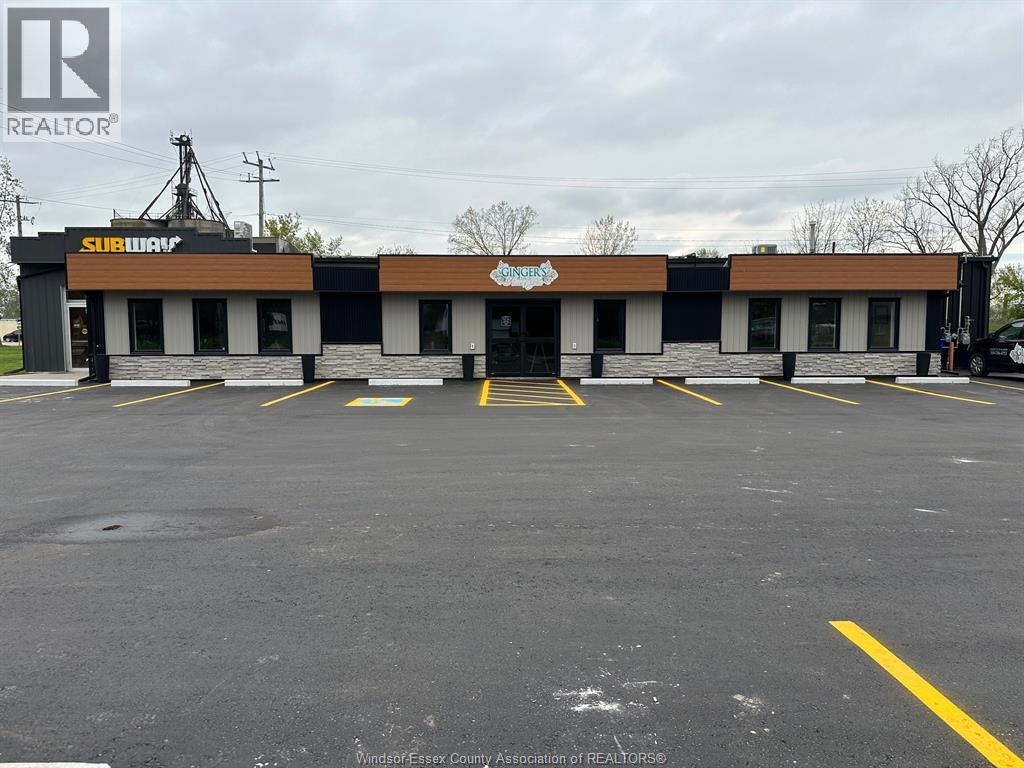 A Subway restaurant with a parking lot in front.