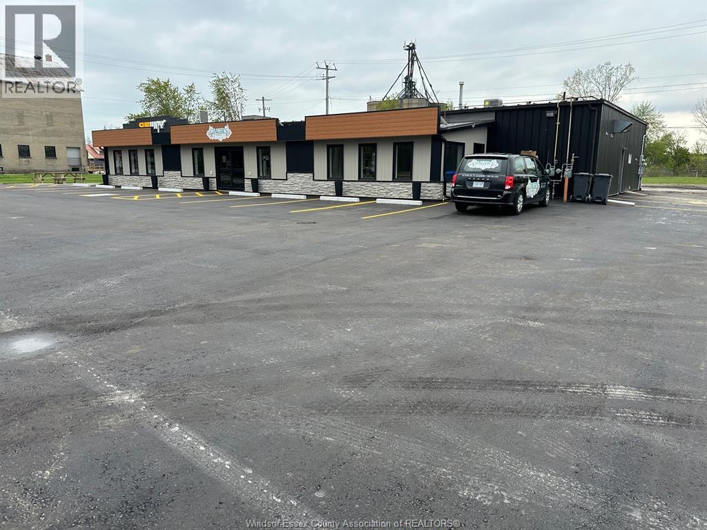 A parking lot with a building and a car.