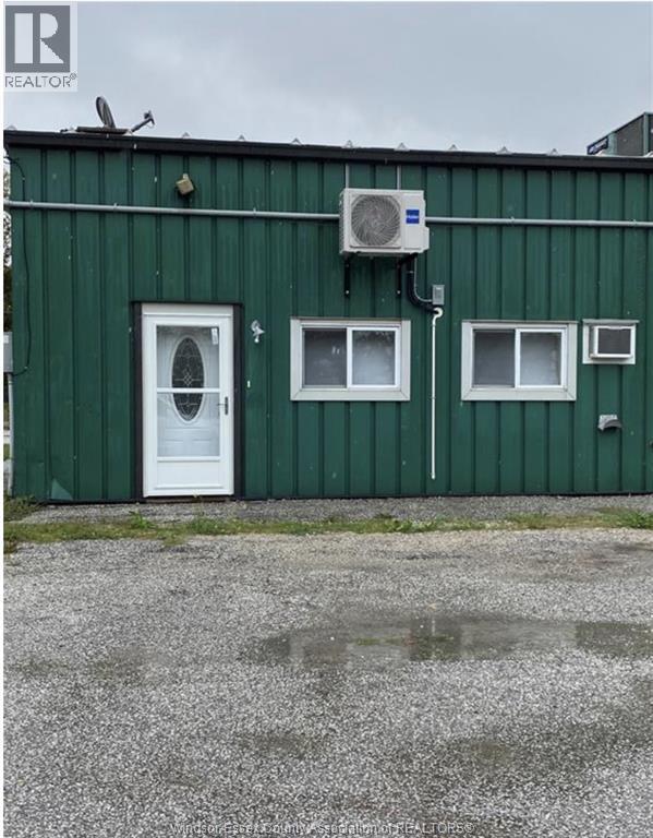 A green building with a white door and windows.