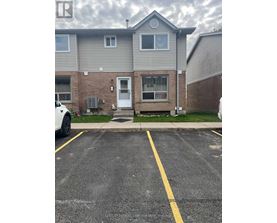 A grey house with a white car parked in front.