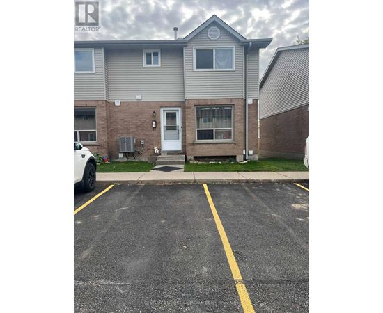 A grey house with a white car parked in front.