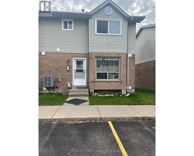 A grey house with a white door and windows.