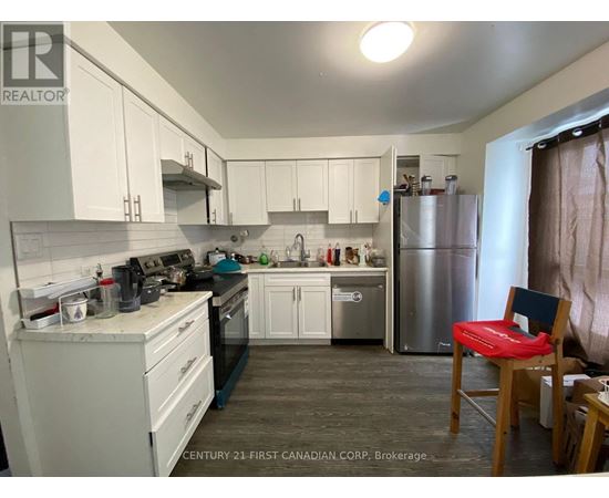 A kitchen with white cabinets and a stainless steel refrigerator.