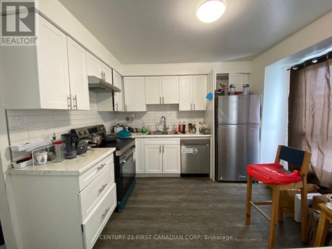 A kitchen with white cabinets and a stainless steel refrigerator.