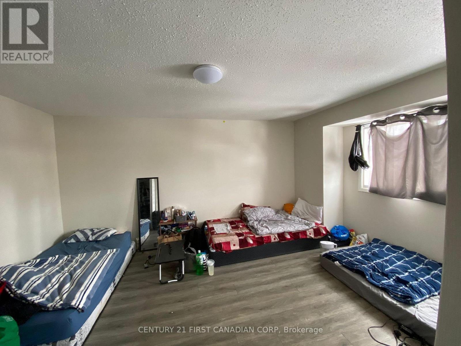 A bedroom with two beds and a desk with a chair.
