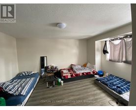 A bedroom with two beds and a desk with a chair.