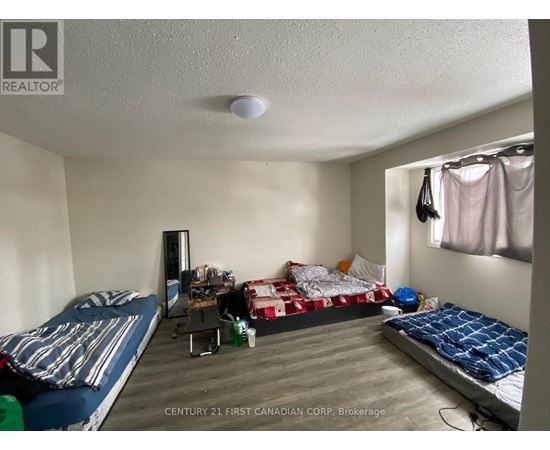 A bedroom with two beds and a desk with a chair.