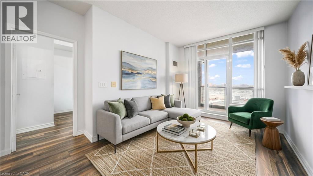 A living room with a grey couch, a green chair, a coffee table, and a painting on the wall.
