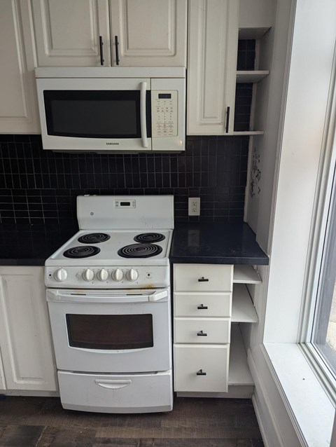 A white stove and microwave in a kitchen.