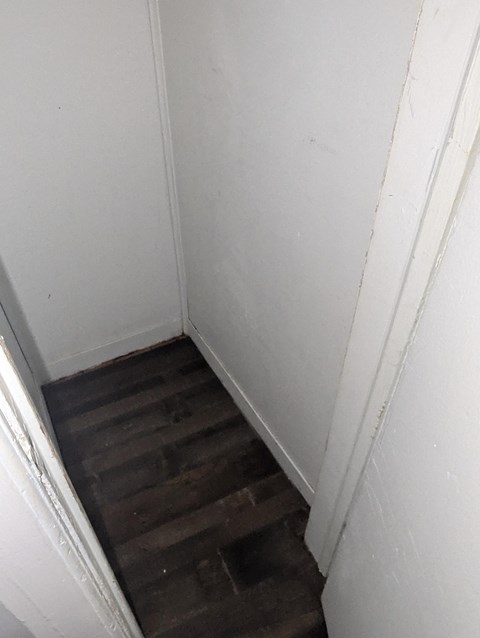 A stairway with wooden steps and white walls.