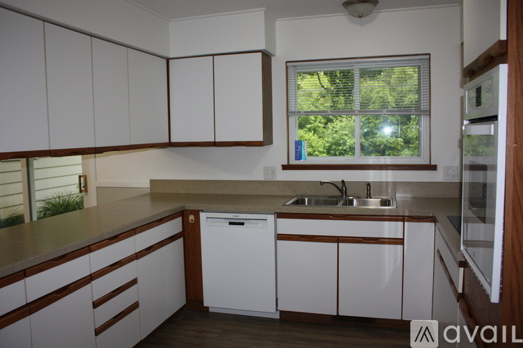A kitchen with white cabinets and a window.