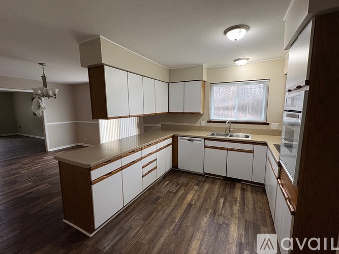 A room with a large window and carpeted floor.