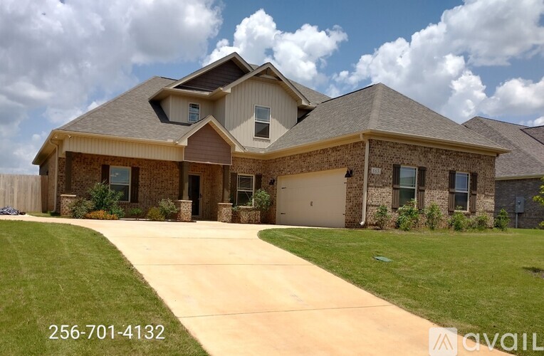 A house with a driveway in front and a phone number on the side.
