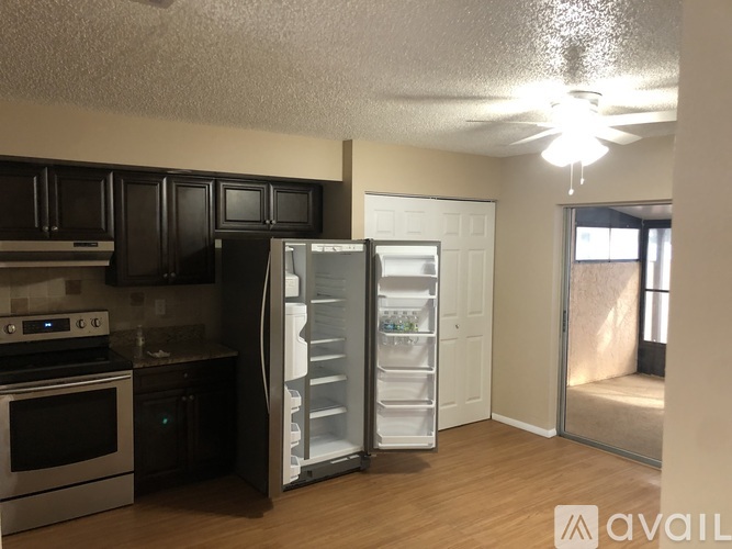 A kitchen with a refrigerator that is open and a stove top oven.