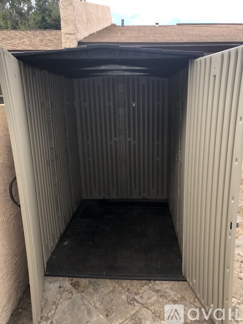 A small, dark-colored room with a doorway leading to a darker space.