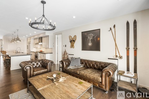 A living room with a brown leather couch and a wooden coffee table.