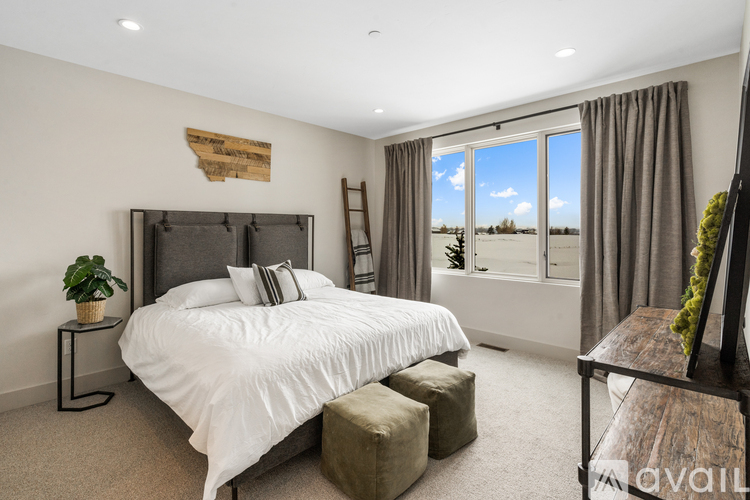 A bedroom with a large bed and a window overlooking a field.