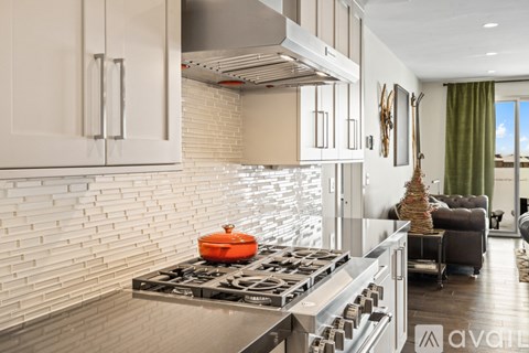 A modern kitchen with a stove top oven and a range hood.