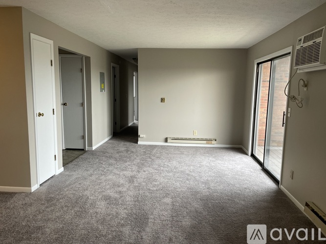 A spacious room with carpeted floor and a bench in the middle.