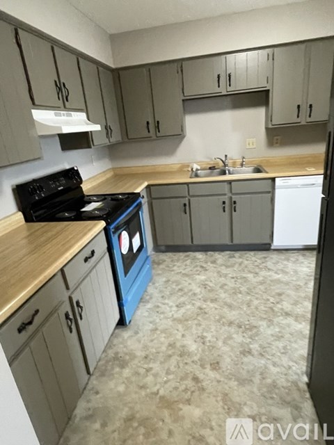 A kitchen with a blue stove top oven and a white dishwasher.