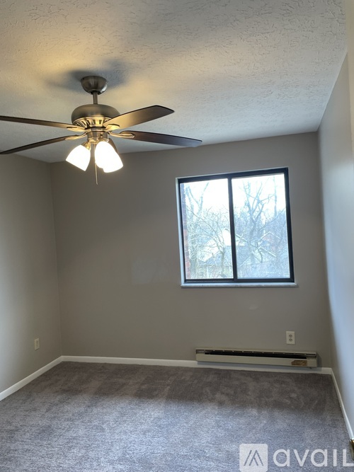 A room with a ceiling fan and a window.