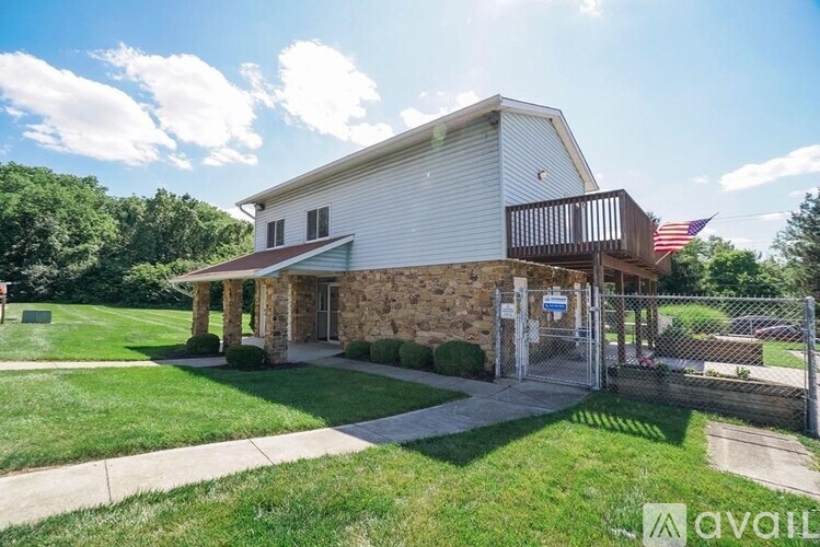 A house with a flag on the porch and a sign that says "available".