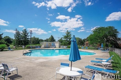 A pool area with chairs and umbrellas is available for use.