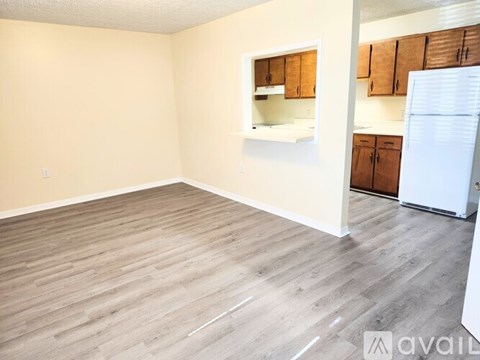 A kitchen area with wooden cabinets and a white refrigerator.