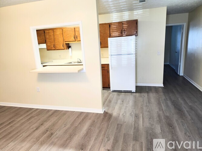 A kitchen with white appliances and wooden cabinets.