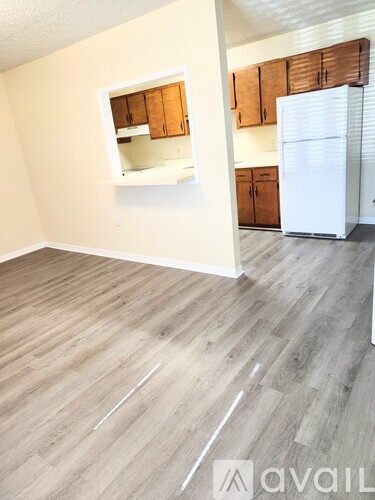 A kitchen with wooden cabinets and a white refrigerator.