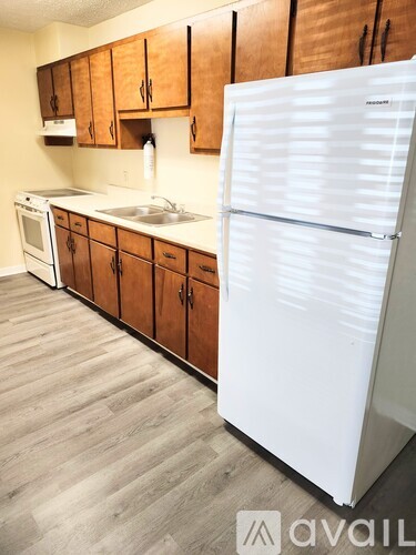 A kitchen with wooden cabinets and a white refrigerator.