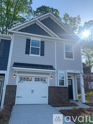 A house with a white garage door and a black door is shown.