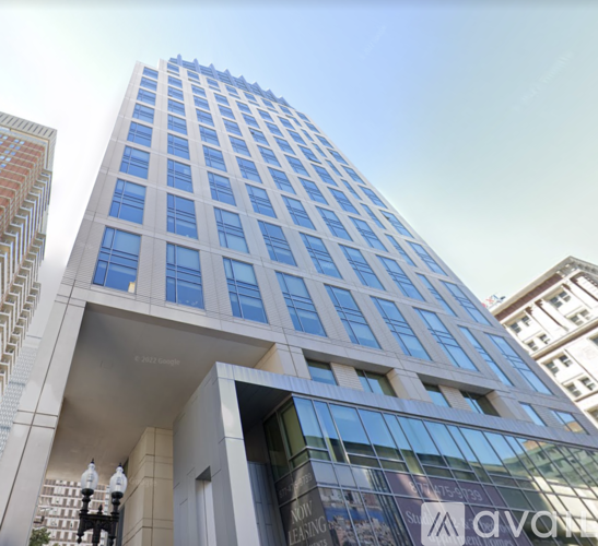 A tall building with a glass facade and a logo that reads "avat".
