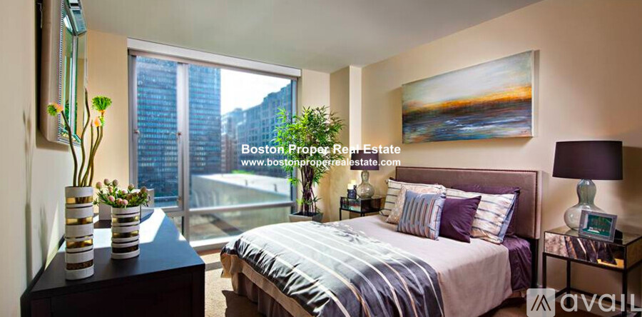 A bedroom with a large bed and a painting on the wall.